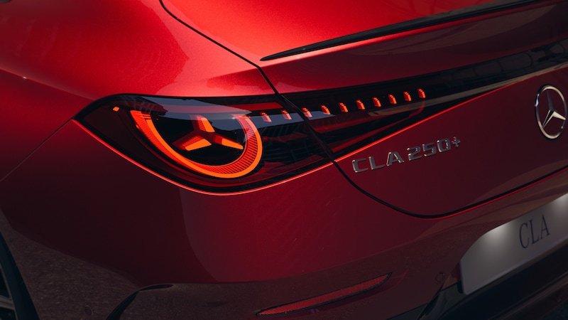 Das rote Heck des Mercedes-Benz CLA Elektrisch zeigt die leuchtende Rückleuchte und den Schriftzug CLA 250+.