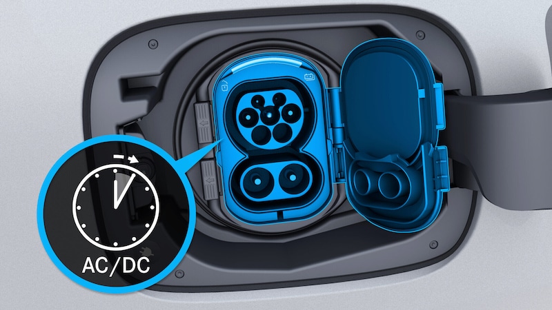 Der geöffnete Ladeanschluss des Mercedes-Benz CLA Elektrisch zeigt die blau hervorgehobene AC/DC-Ladebuchse mit geöffneter Abdeckung.