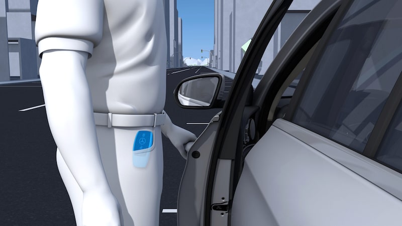 Eine Person mit Schlüssel in der Tasche steht neben der geöffneten Fahrertür des Mercedes-Benz CLA Elektrisch.