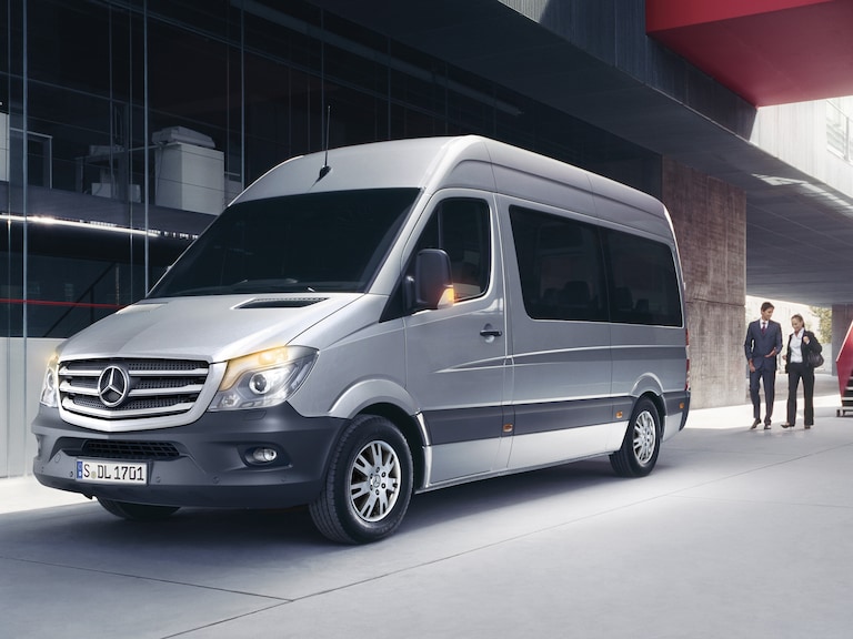 Mercedes-Benz T-Klasse. Ruimte, comfort en stijl voor elke gelegenheid Groep jonge vrienden stapt in een zwarte Mercedes-Benz T-Klasse geparkeerd voor een modern gebouw, genietend van een zonnige dag.