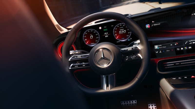 Das Cockpit des Mercedes-Benz CLA Elektrisch zeigt Lenkrad, digitale Anzeigen und zentrale Bedienelemente mit rot beleuchteten Akzenten.