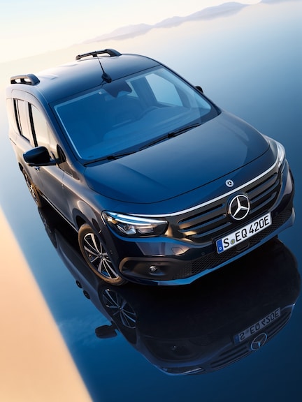 Vans and camper models | Mercedes-Benz The Mercedes-Benz EQT stands on a mirror-smooth surface reminiscent of water - a mountain range can be glimpsed on the horizon.