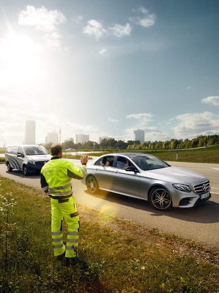 Mercedes-Benz Service24h | Mercedes-Benz A Mercedes-Benz service technician waving from the roadside to a child sitting in an approaching Mercedes.