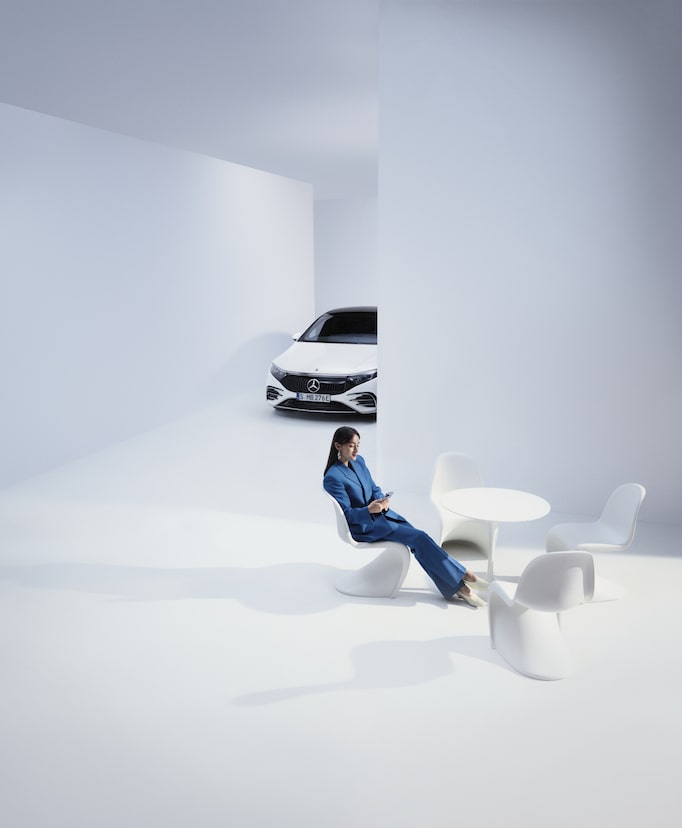 Recall & field measures | Mercedes-Benz A person sitting next to the Mercedes-Benz vehicle and looking at the cell phone.