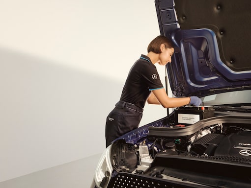 Batteries de démarrage | Mercedes-Benz Un technicien effectuant les réglages de la batterie.