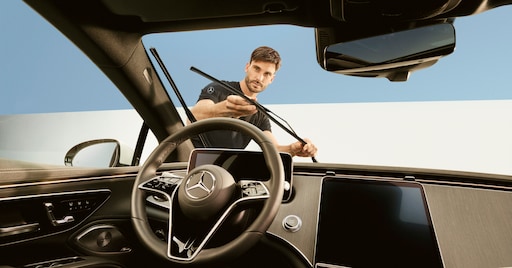 Balais d'essuie-glace | Mercedes-Benz Un technicien réparant les balais d'essuie-glace d'un véhicule Mercedes-Benz.