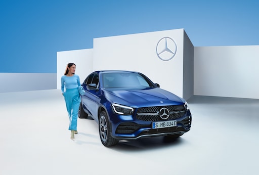 Une femme marche à côté de sa Mercedes-Benz.