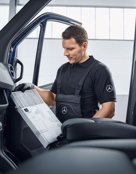 Mercedes-Benz | Wartung | Regelmäßige Wartung Mercedes-Benz Mechaniker wechselt Luftfilter.