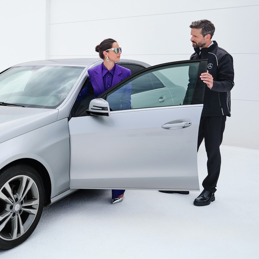 Service Select | Mercedes-Benz 2 persons stands at the side door of a Mercedes-Benz vehicle.
